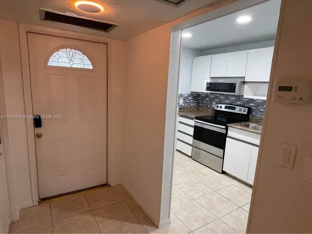 a kitchen with stainless steel appliances granite countertop a stove a refrigerator and a microwave