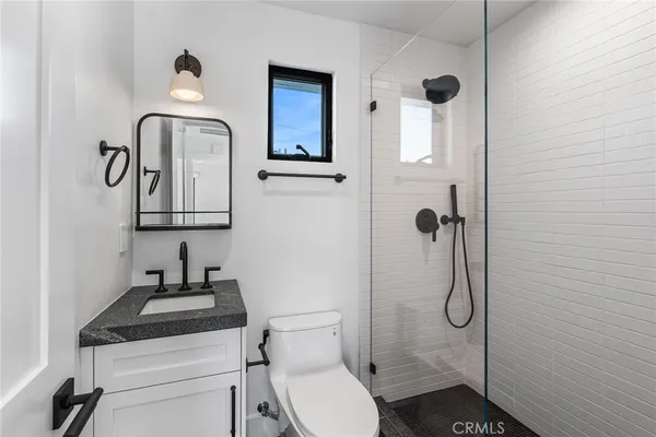 a bathroom with a granite countertop toilet sink and mirror