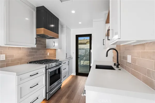 a kitchen with stainless steel appliances granite countertop a sink stove and refrigerator