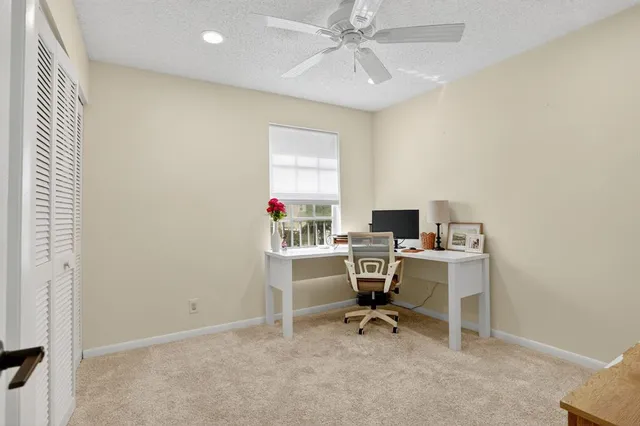 a view of a workspace with furniture and a window