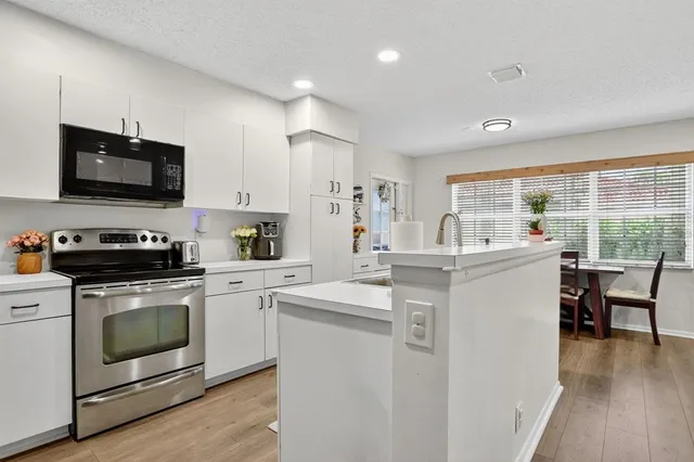 a kitchen with appliances a sink and cabinets