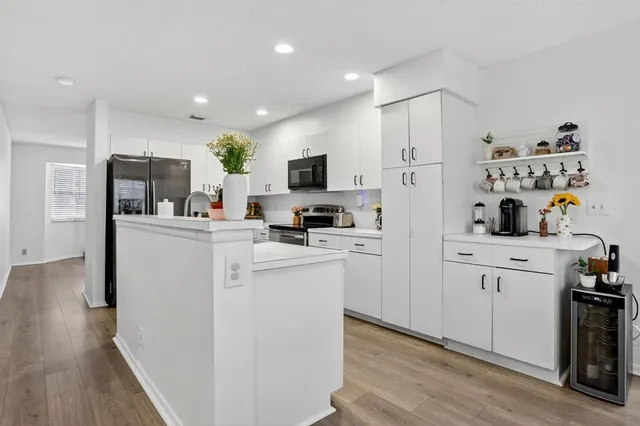 a kitchen with kitchen island white cabinets and refrigerator
