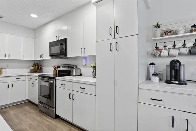 a kitchen with white cabinets and appliances