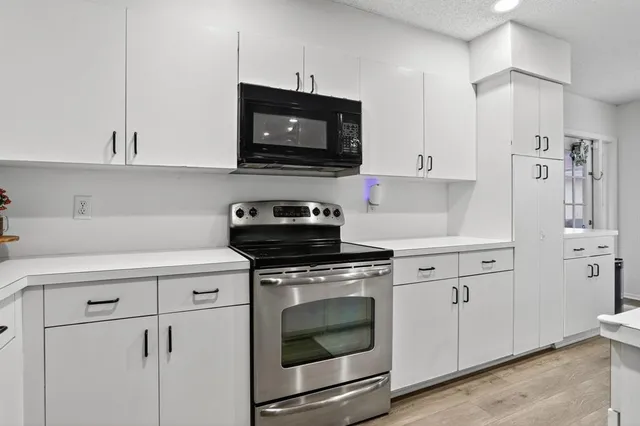 a kitchen with white cabinets and stainless steel appliances