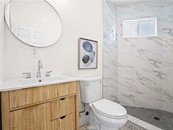 a bathroom with a toilet a sink and mirror