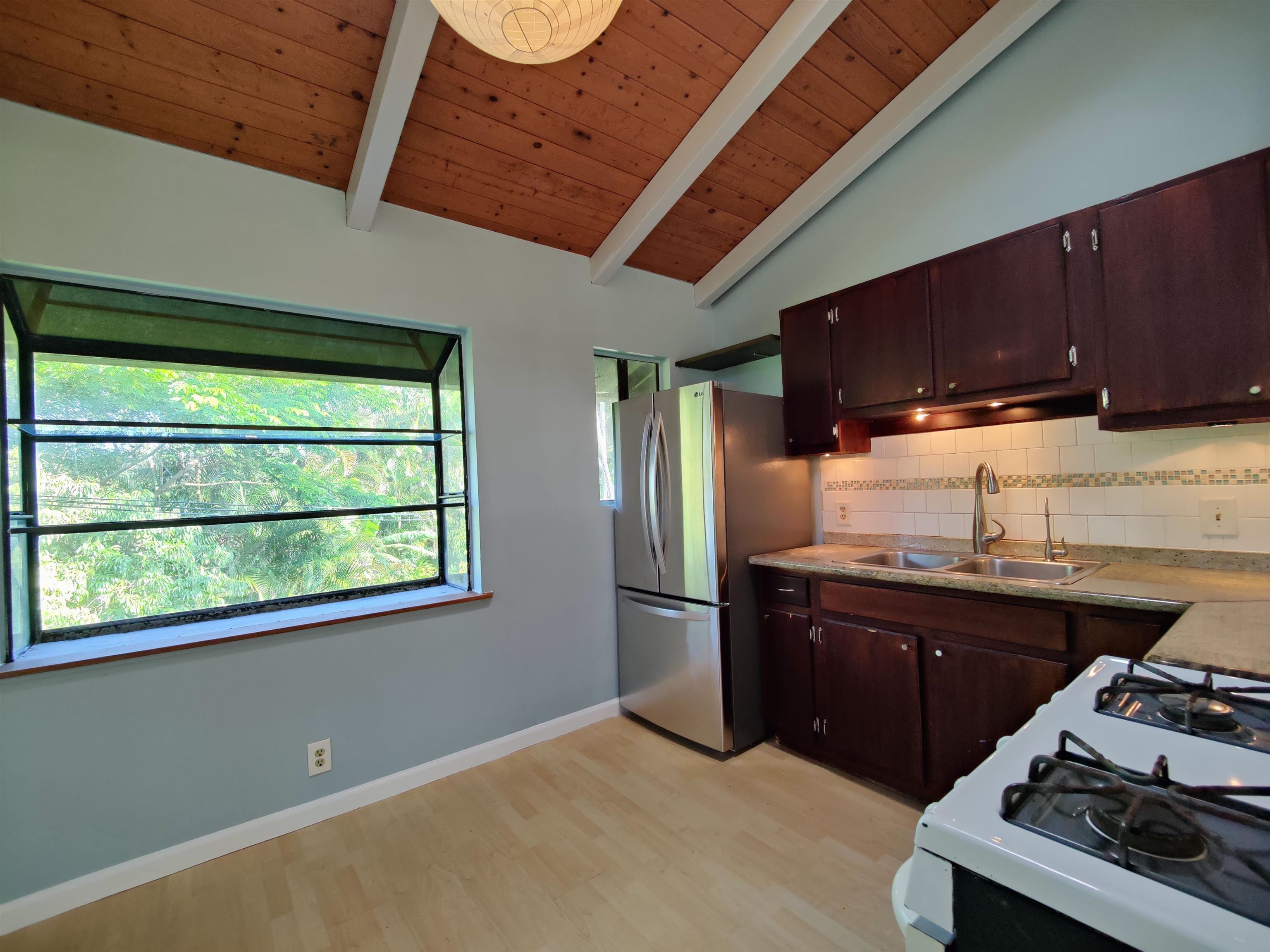 142 Peahi Road Haiku, HI 96708 - Photo 6 of 21 a kitchen with a refrigerator and a stove top oven
