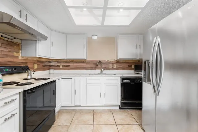 a kitchen with stainless steel appliances granite countertop a refrigerator and a stove
