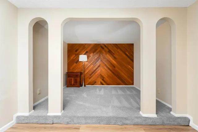 a bedroom with a bed and a large window with wooden floor