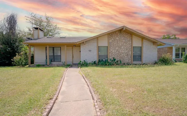 a front view of house with yard and trees around