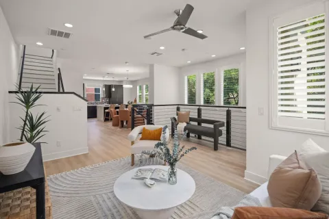 a living room with furniture kitchen view and a large window