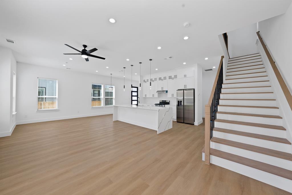 302 East 7th Street Dallas, TX 75203 - Photo 11 of 30 a view of an empty room with wooden floor and stairs