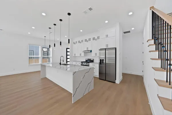 a view of kitchen with stainless steel appliances refrigerator oven and cabinets