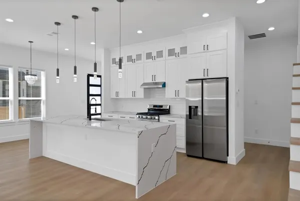 a kitchen with stainless steel appliances granite countertop a refrigerator a sink and a stove