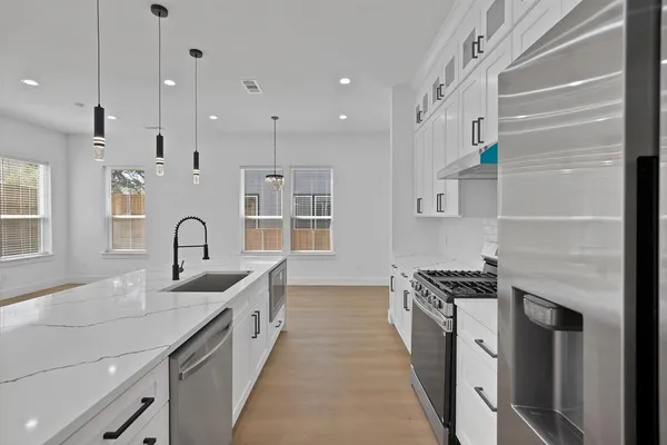 a kitchen with stainless steel appliances a sink stove and cabinets