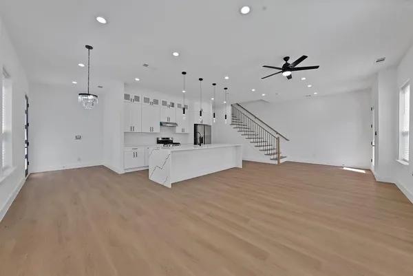 a view of empty room with wooden floor and ceiling fan