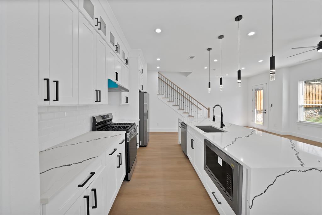 302 East 7th Street Dallas, TX 75203 - Photo 8 of 30 a large white kitchen with lots of counter space