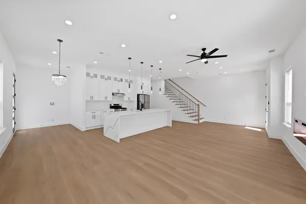 a view of an empty room with a ceiling fan and window