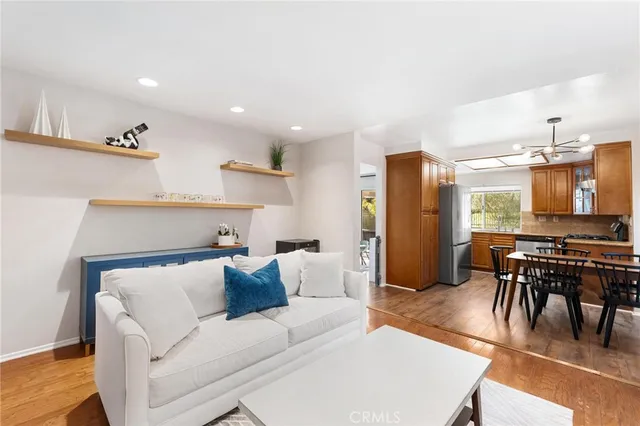 a living room with furniture and a dining table with kitchen view