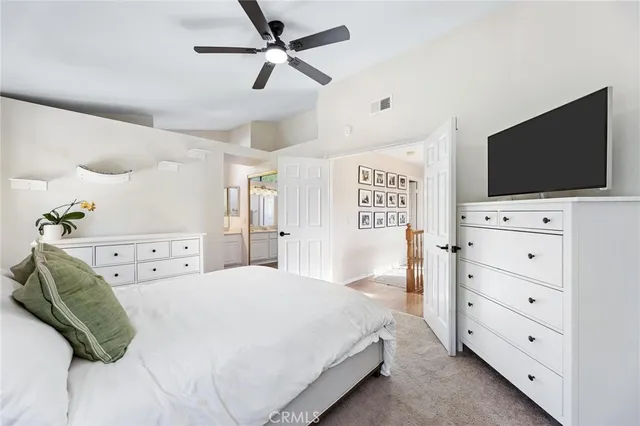 a spacious bedroom with a bed and a flat screen tv