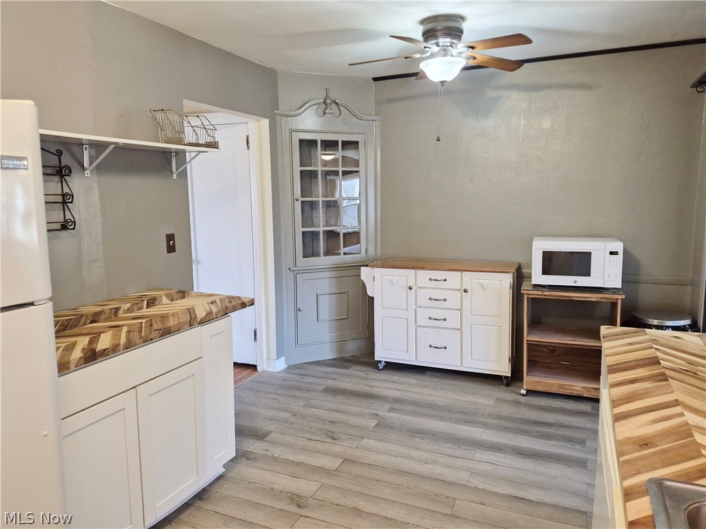 351 Niles Vienna Road Vienna, OH 44473 - Photo 7 of 30 Kitchen featuring butcher block counters, white cabinets, white appliances, ceiling fan, and light wood-style flooring