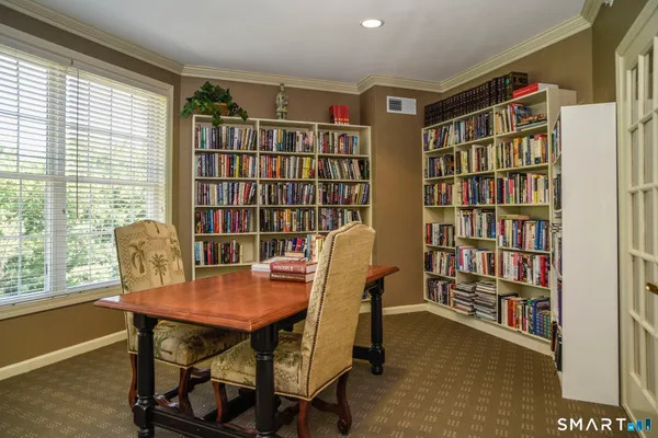 a view of a workspace with furniture and a bookshelf