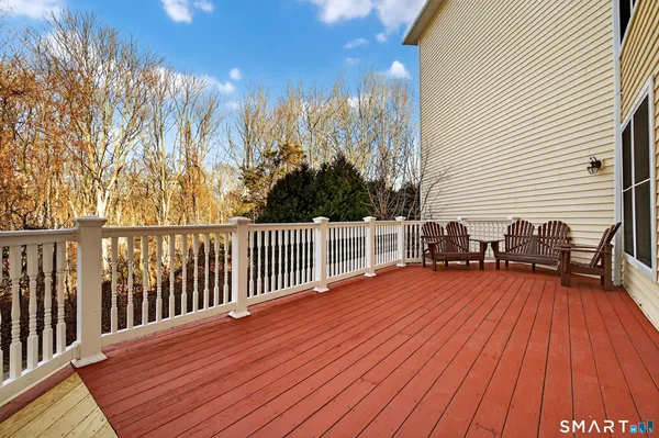a balcony with wooden floor table and chairs