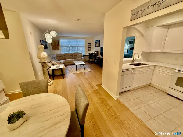 a living room with stainless steel appliances furniture and a kitchen view