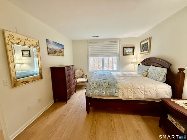 a bedroom with bed and wooden floor