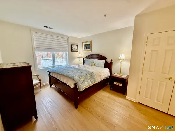 a bedroom with a bed and wooden floor