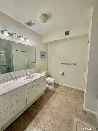a bathroom with a double vanity sink toilet and shower