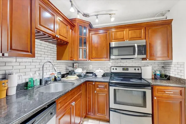 a kitchen with stainless steel appliances granite countertop a sink stove and microwave