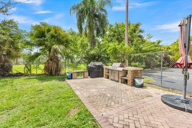 a view of a backyard with potted plants and palm trees
