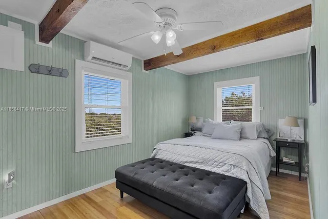 a bedroom with a bed and a table with wooden floor