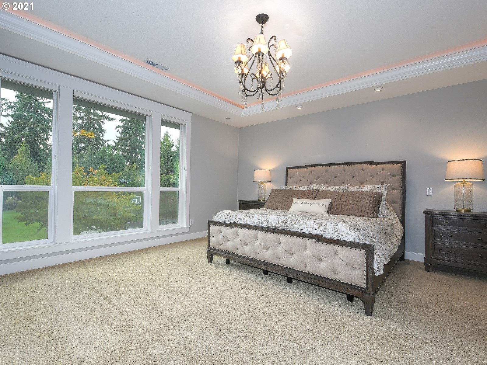 22706 Northeast 7th Court Ridgefield, WA 98642 - Photo 14 of 32 a spacious bedroom with a large bed and a chandelier