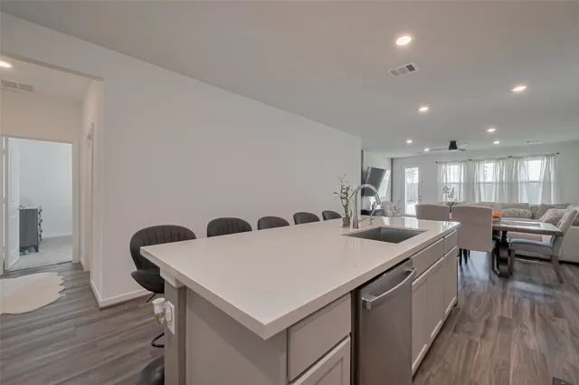 a kitchen with a kitchen island wooden floor and white appliances