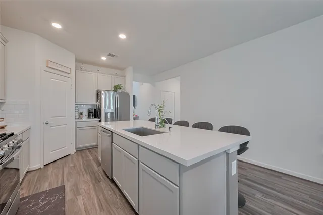 a kitchen with a sink cabinets and wooden floor