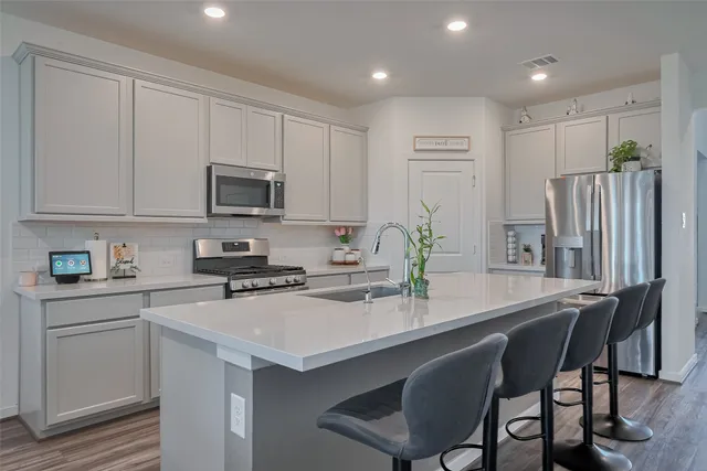 a kitchen with appliances cabinets and furniture