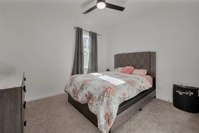 a bed sitting in a bedroom next to a lamp