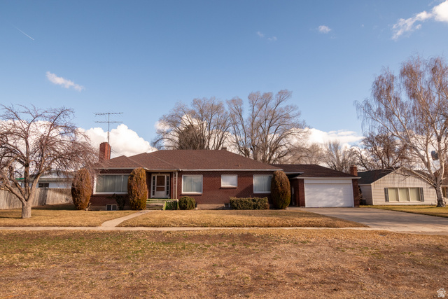 160 North 100 W Street Beaver, UT 84713 - Photo 1 of 36 Ranch-style home with driveway, a front lawn, a chimney, brick siding, and a garage