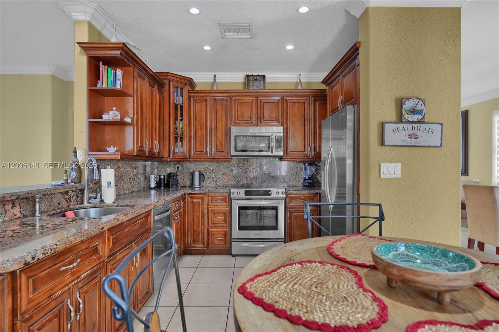 6114 Southwest 158th Pass Miami, FL 33193 - Photo 12 of 37 a kitchen with stainless steel appliances granite countertop a stove a sink and a refrigerator