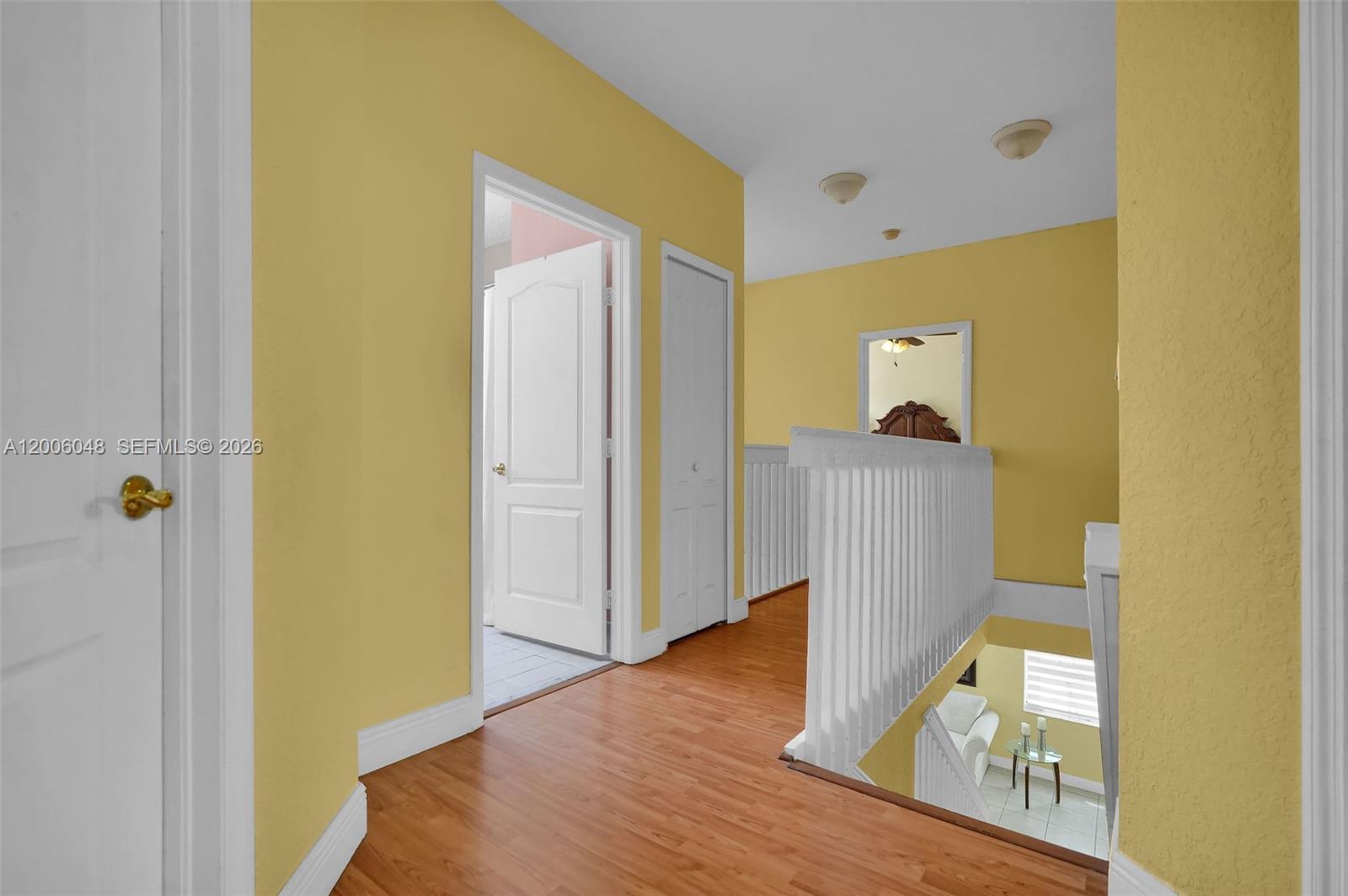 6114 Southwest 158th Pass Miami, FL 33193 - Photo 17 of 37 a view of a hallway with wooden floor and a bathroom