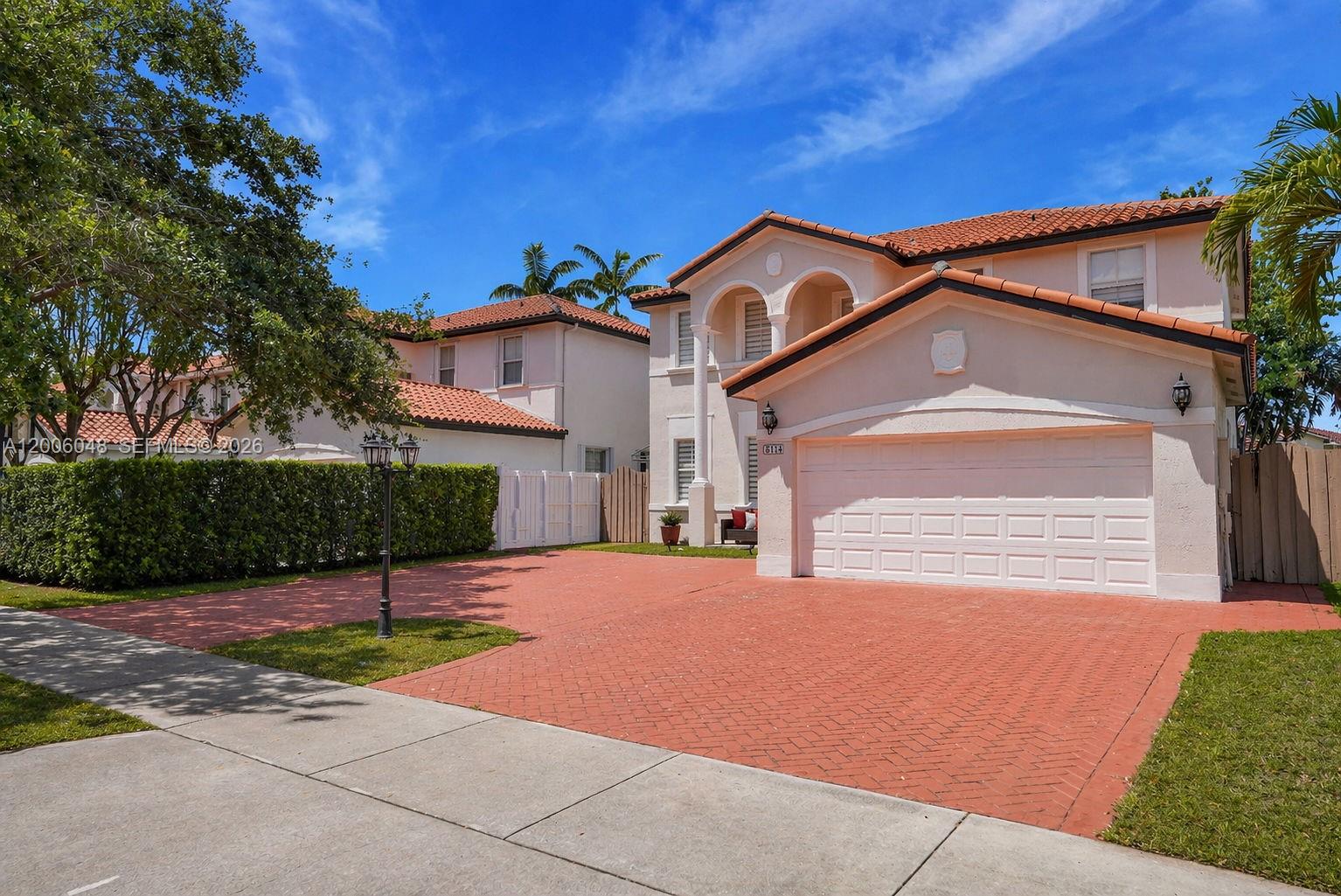 6114 Southwest 158th Pass Miami, FL 33193 - Photo 2 of 37 a front view of a house with a yard and garage
