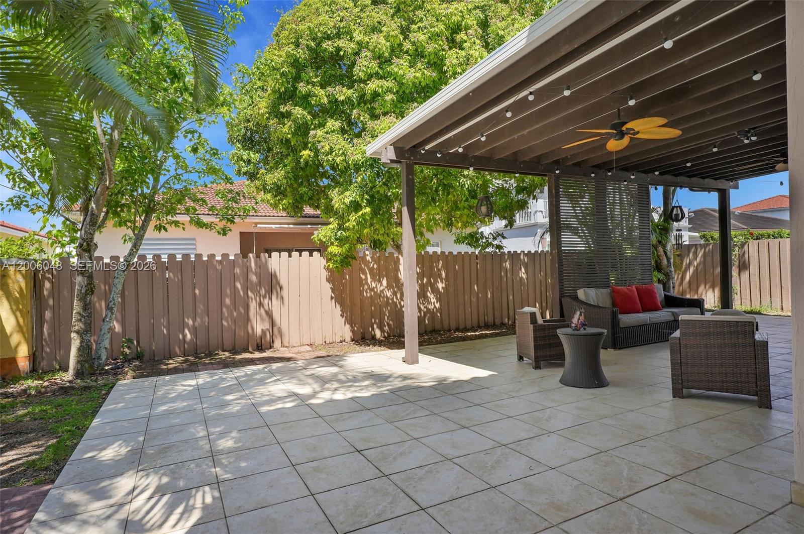 6114 Southwest 158th Pass Miami, FL 33193 - Photo 32 of 37 a view of a patio with table and chairs under an umbrella with a small yard