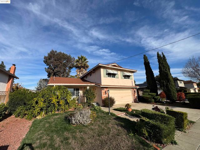 a view of a white house with a big yard and a large tree