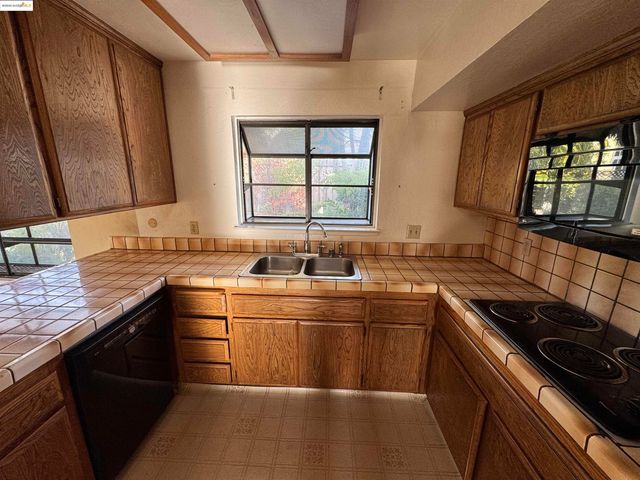 a kitchen with a sink stove top oven and cabinets