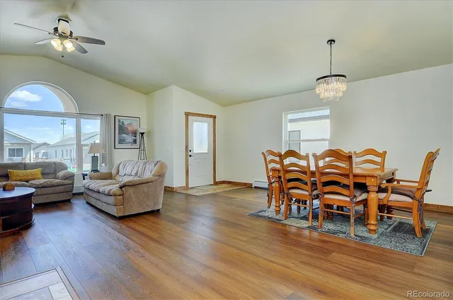 a dining room with furniture a chandelier and wooden floor