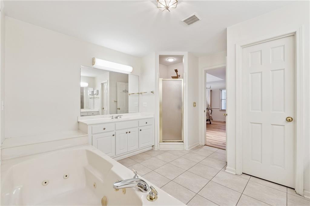 1387 Springdale Road Gainesville, GA 30501 - Photo 22 of 46 a spacious bathroom with a shower a sink and a mirror