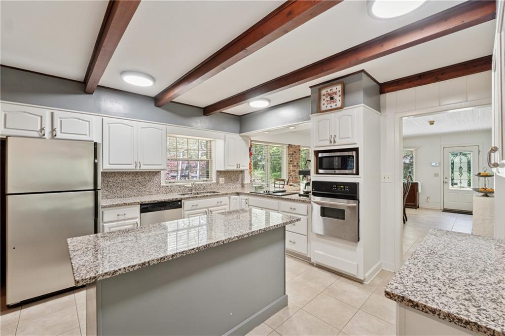 1387 Springdale Road Gainesville, GA 30501 - Photo 9 of 46 a large kitchen with granite countertop a large counter top stainless steel appliances and cabinets