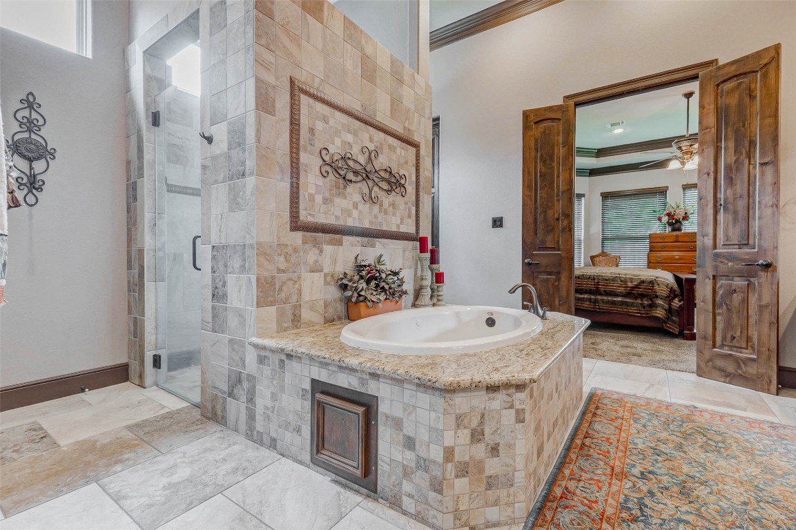4315 Wickby Street Fulshear, TX 77441 - Photo 32 of 46 Elegant primary bathroom features a luxurious tub and a separate glass-enclosed shower.