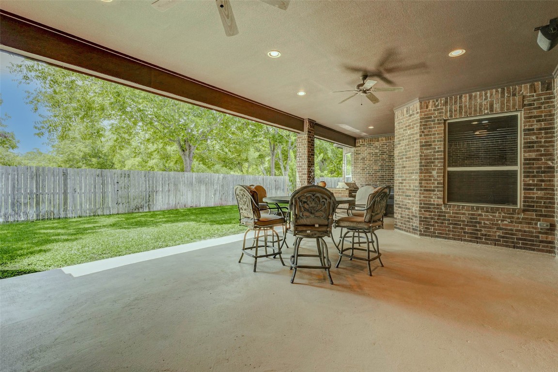 4315 Wickby Street Fulshear, TX 77441 - Photo 41 of 46 Large covered patio with ceiling fans, recessed lighting and speaker pre-wires. Perfect for outdoor dining and entertaining. The area overlooks a fenced backyard with lush trees.
